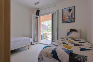 a bedroom with a bed and a sliding glass door at Villa avec piscine in Plan-de-la-Tour +112 photos
