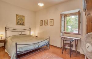 Un dormitorio con una cama y un escritorio y una ventana. en Il Loggiato, en Monte San Savino