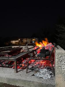 a fire pit with a bench and a fire grill at Kapo TEAM , colibri in Villa Amancay