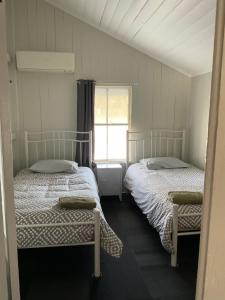 two beds in a small room with a window at 19 Cobb Lane in Winton