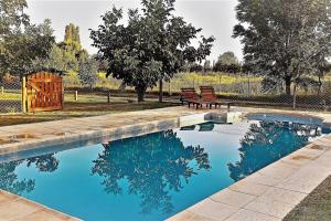 a swimming pool with a bench and trees in a yard at La casita Espiritual in San Rafael