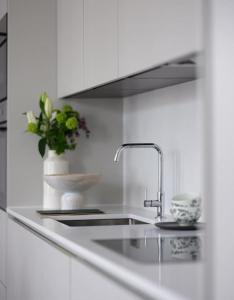 a kitchen counter with a sink and a vase of flowers at 3 Bed Corner House Portobello Rd in London