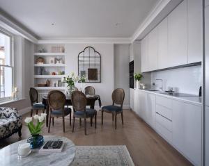 a kitchen and dining room with a table and chairs at 3 Bed Corner House Portobello Rd in London