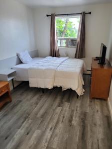 a bedroom with a large bed and a window at Vivian Motor Hotel in Neepawa