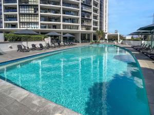 a large blue swimming pool in front of a building at Incredible ocean views 3 Bed 18th floor in Gold Coast