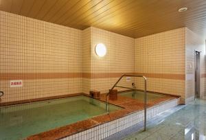 a large swimming pool in a building with at Hotel Frontier Iwaki in Iwaki