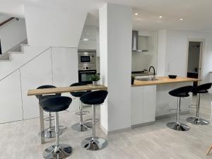a kitchen with a counter and stools in a room at Amencer en Llas in Foz