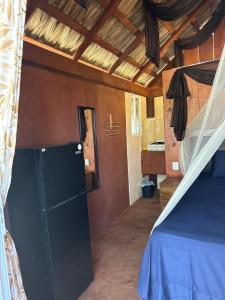 a room with a bed and a refrigerator in it at Cabaña Croton Punto Surf Barra la Saladita in La Salada