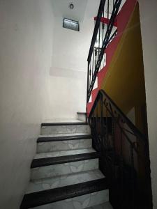 una scala in un edificio con una ringhiera rossa e nera di Casa De Liz a San Cristóbal de Las Casas