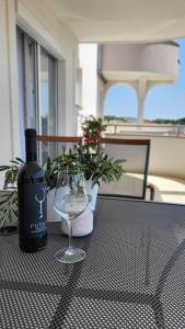 Una botella de vino y una copa en una mesa en Mila Apartments Zadar, en Zadar