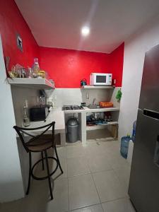 a small kitchen with a red wall and a stove at Estancia García in San Cristóbal de Las Casas +19 photos