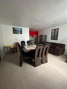 a dining room and living room with a table and chairs at Estancia García in San Cristóbal de Las Casas