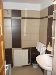 Un baño con un lavabo y un inodoro y un lavabo. en Pensiunea Laura, en Bran