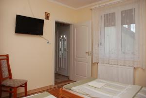a bedroom with a bed and a television on a wall at Zöldike Vendégház in Kaposvár