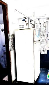 a white refrigerator in a room with a wall at Apartamento POSADAS in Posadas
