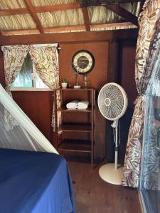 a bedroom with a fan and a window and a table at Cabaña Buganvilia Punto Surf Barra La Saladita in La Salada