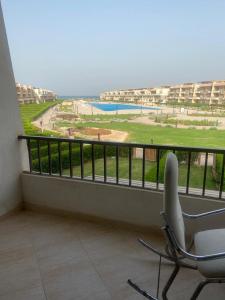 a balcony with a chair and a view of a pool at Ain Sokhna Chalet in Ain Sokhna