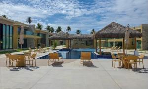 Un complejo con piscina, mesas y sillas. en Casa Morada do toque l By milagres hospitalidade, en São Miguel dos Milagres