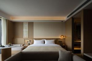 a hotel room with a large bed and a couch at Yanyu Yunxi Resort Hotel 烟雨云兮酒店 in Fenghuang County