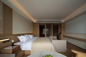a hotel room with a bed and a projector screen at Yanyu Yunxi Resort Hotel 烟雨云兮酒店 in Fenghuang County