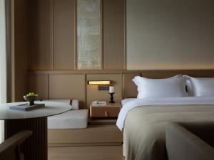a hotel room with a bed and a table at Yanyu Yunxi Resort Hotel 烟雨云兮酒店 in Fenghuang County