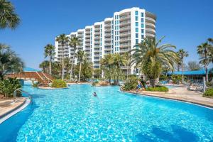 a swimming pool in front of a resort at 1st Floor Palms of Destin Resort Updated Condo with Beach Shuttle in Destin