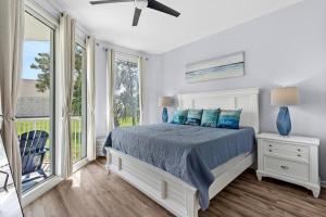 a bedroom with a bed with blue pillows at 1st Floor Palms of Destin Resort Updated Condo with Beach Shuttle in Destin +41 photos