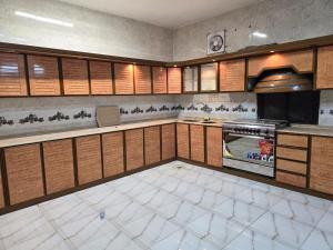 a large kitchen with wooden cabinets and a stove at شقة 3 غرف مع سطوح مستقل بخميس مشيط in Khamis Mushayt