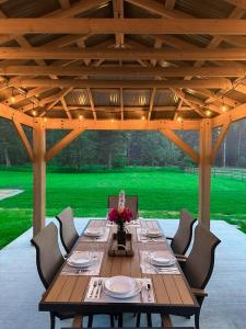 a wooden table in a pavilion with a green lawn at Timber Ridge in Columbia Falls