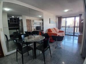 a living room with a couch and a table and chairs at Flat Atlântico Meireles by Escala in Fortaleza