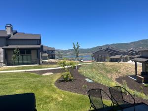 a view of the backyard of a house with chairs at 4 bd Ski Villa with Hot Tub and Bunk Room by lake! in Heber City