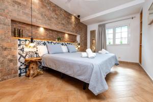a bedroom with a large bed with a brick wall at Calas Beach Corralejo in Corralejo
