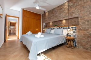 a bedroom with a large bed with a brick wall at Calas Beach Corralejo in Corralejo
