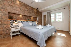 a bedroom with a bed and a brick wall at Calas Beach Corralejo in Corralejo