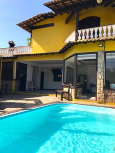 a villa with a swimming pool in front of a house at Pousada Gente Bonita João Fernandes in Búzios
