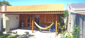 a porch with a hammock in front of a house at Casa aconchego perto da praia in Guaratuba