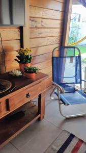 a blue chair sitting next to a table with a tv at Casa aconchego perto da praia in Guaratuba