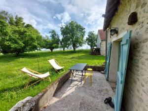 a patio with two chairs and a table and chairs at Retraite Champêtre avec Home Cinéma et Verger Libre Cueillette, près de la Loire et des Châteaux - FR-1-590-435 in Gémigny