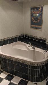 a bath tub in a bathroom with a tile floor at Apartmán Jáchymov in Jáchymov