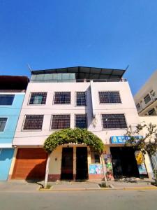 ein weißes Gebäude mit vielen Fenstern in der Unterkunft Hospedaje Hipito in Nazca