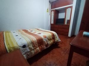 ein Schlafzimmer mit einem Bett, einer Kommode und einem Spiegel in der Unterkunft Hospedaje Hipito in Nazca