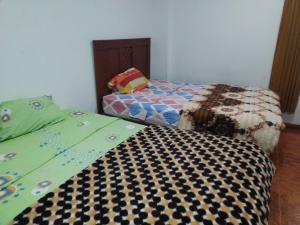 ein Schlafzimmer mit einem Bett mit einer Bettdecke darauf in der Unterkunft Hospedaje Hipito in Nazca