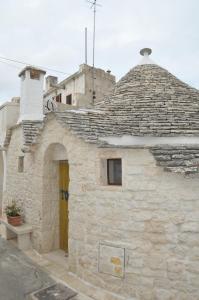 un edificio in pietra con tetto e porta gialla di Trullo Relax ad Alberobello