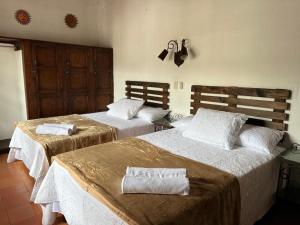 a bedroom with two beds with towels on them at Hotel Casa Blanca Antigua Guatemala in Antigua Guatemala