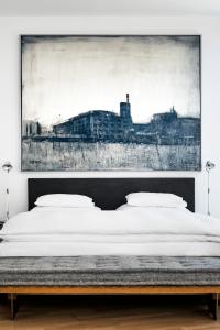 a bedroom with a large painting above a bed at Augarten Art Hotel, a Member of Design Hotels in Graz
