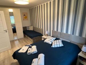 a bedroom with a blue bed with towels on it at Apartament Szept Morza in Debina