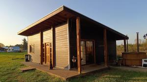 a small house with a cat standing outside of it at Cabaña Relmu Osorno con tinaja in Pichil