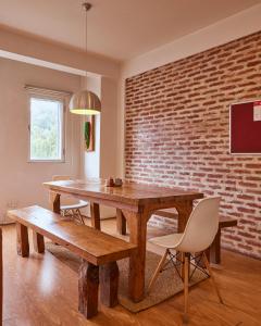 a dining room with a wooden table and a brick wall at Ananya Apartments Phase 1 in Kathmandu