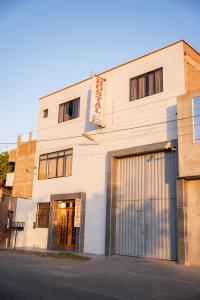 un edificio bianco in una strada con garage di Hostal Los Balcones II a Nazca Altre 9 foto