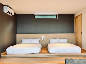 高松SETO CLAS for SLEEP -Oceanside AJI SASAO-的两张睡床坐在一个房间里长凳上